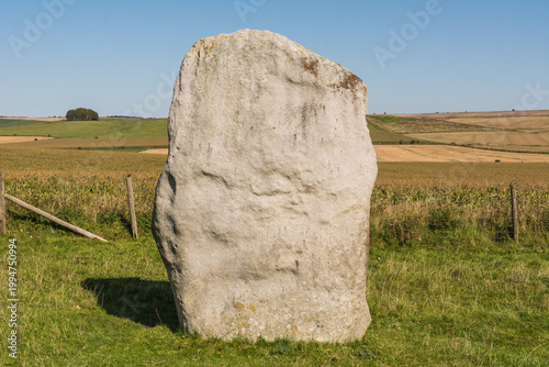 Ancient Neolithic Stone Circle at Avebury Henge in a Green Landscape under Clear Sky
