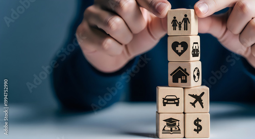 Person stacking wooden blocks with various icons on them