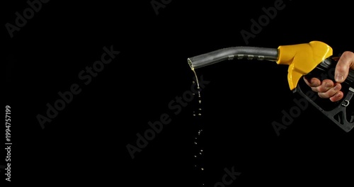 Super slow motion (1000 fps) fuel drops dripping from gasoline nozzle, symbol of depletion and fuel shortage. Minimal liquid flow on black background, dramatic lighting, energy crisis concept.