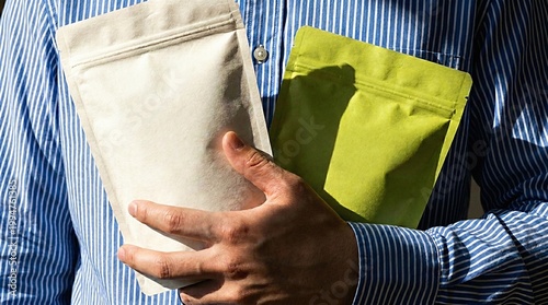Man holding two empty stand-up pouch bags for mockup
