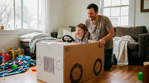 Happy father playing with son in a handmade cardboard box car at home
