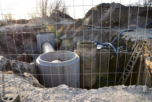 Installation of concrete manhole rings for sewage and drainage system in a trench
