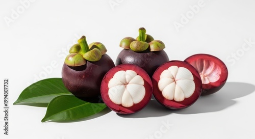 Fresh mangosteen fruits with green leaves isolated on white background