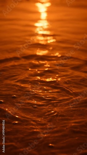Golden Hour Sunlight Reflecting on Rippling Water Surface with Concentric Circles Creating a Mesmerizing Abstract Pattern
