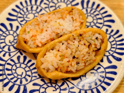 High angle view of two inarizushi served on patterned ceramic plate