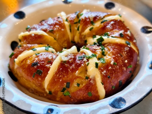 Close-up of a garlic cream cheese bagel with green onion sprinkles