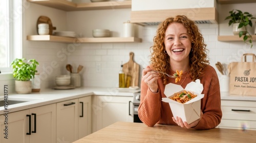 Happy woman with curly red hair enjoying a delicious pasta meal from a takeout container