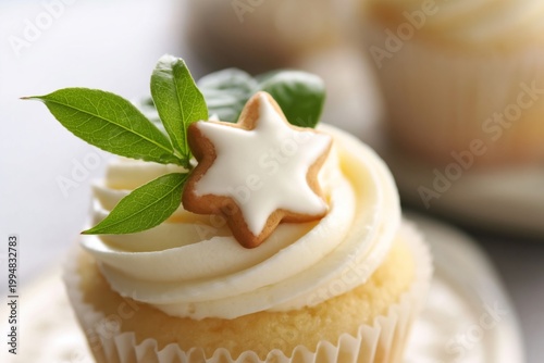 Fresh Cupcake With White Frosting and Star Cookie on Top With Green Leaves in...
