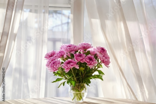 Vibrant Pink Flowers in a Clear Vase on a Wooden Table Near a Sunlit Window