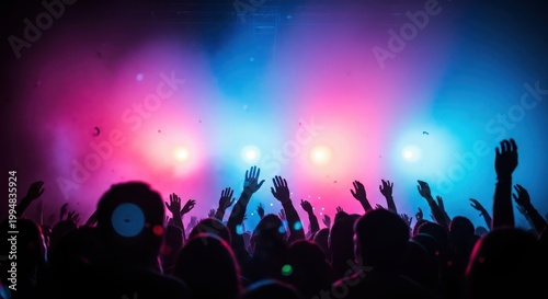 Silhouetted crowd with raised hands at a music concert