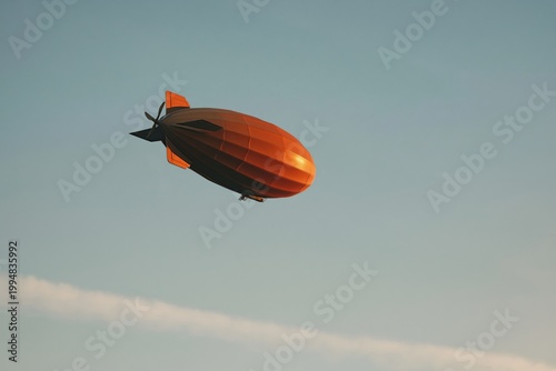 Flying Orange Airship Over Mountains in Daylight With Clear Sky