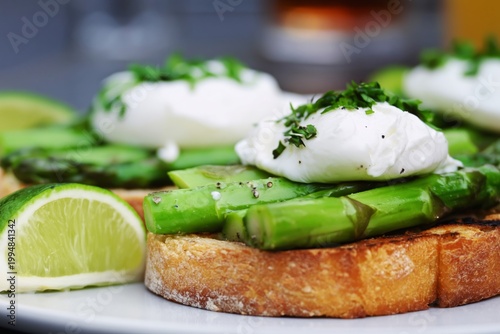 Breakfast With Poached Eggs and Asparagus on Toast With Lime on the Side in a...
