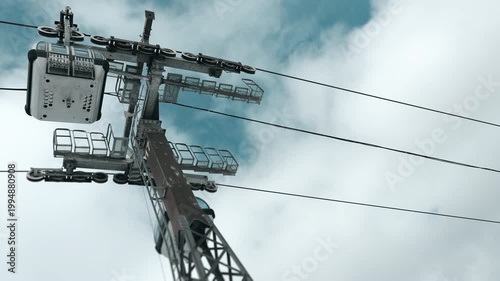 Cable car lift system against cloudy sky at ski resort, mountain transportation infrastructure and travel concept, low angle view.