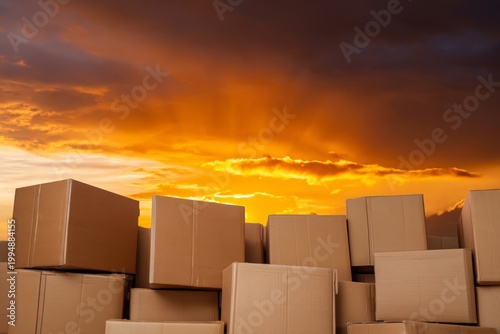 Brown Cardboard Boxes Stacked Against a Colorful Sunset Sky in an Outdoor Set...