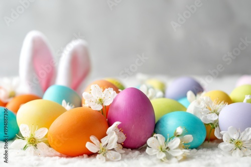 Colorful Eggs and Bunny Ears Arranged on a Table With Flowers During Easter C...