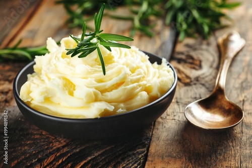 Creamy Mashed Potatoes With Rosemary on a Wooden Table