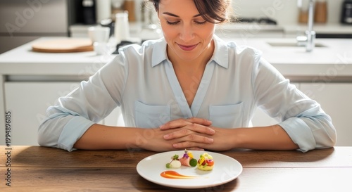 Woman practicing mindful eating with small portion of gourmet food on plate. Concept of healthy weight management, nutrition control, conscious dining and glp-1 therapy lifestyle support.