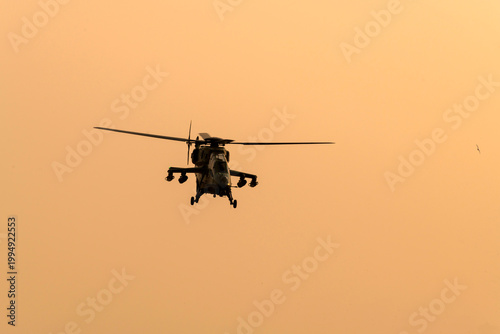 Silhouette Military helicopter air attack during dawn isolated sky