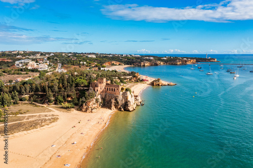 Ferragudo with the Praia Grande (the main beach) and the river Rio Arade, Algarve, Portugal. Beautiful seascape with beach, cave and ocean, Praia Grande beach, Ferragudo, Lagoa, Algarve, Portugal.