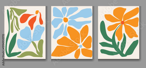 Three colorful floral paintings hang on a gray wall featuring abstract flower designs in orange blue and green hues on white backgrounds