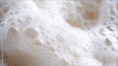 A close-up view of soft, frothy bubbles, creating a textured pattern. This image portrays a delicate and abstract representation of foam.