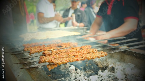 Tasty Adana kebabs are grilling on a bbq in a festival, close up