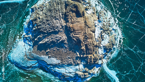 Cuadro en lienzo Aerial Frozen Rocky Outcrop with Cracked Ice Patterns on Winter Lake Top Down