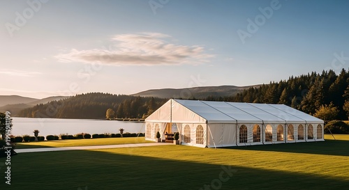 Elegant Marquee Tent Set Up for an Event by a Serene Lake at Sunset.