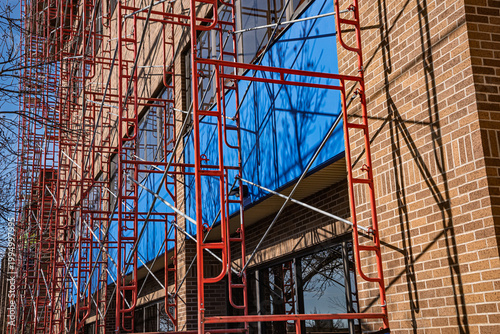Steel scaffolding erected adjacent to multi story building for window cleaning.