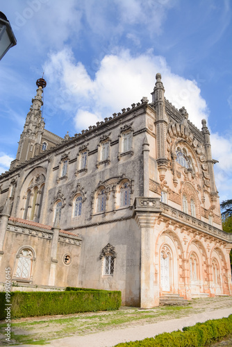Blooming bougainvillea and vegetation in the park in front of the Busaco Palace in Portugal Coimbra region. Themes include travel, cultural heritage, and natural beauty.