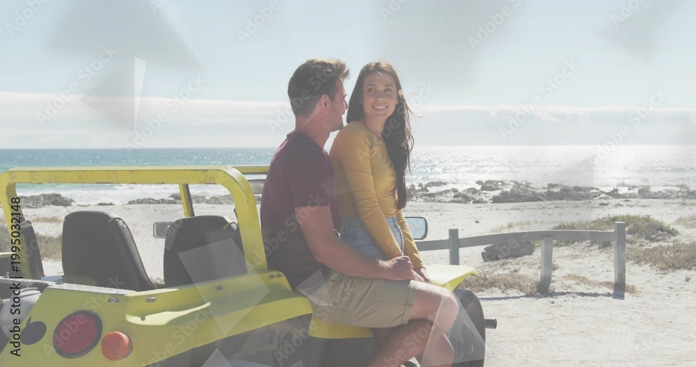 Fototapeta premium Sitting couple smiling, holding on yellow dune buggy at beach, wearing mustard top and maroon tee