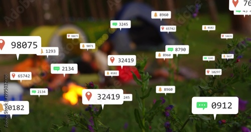 Highlighting flowers with label 32419 at dusk campsite, blurring campers wearing coats by campfire