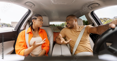 Young African American couple arguing inside a car, expressing frustration and disagreement during travel, illustrating relationship conflict and emotional tension