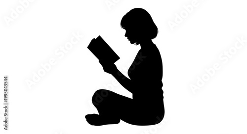 Silhouette of a woman kneeling and absorbed in reading a book