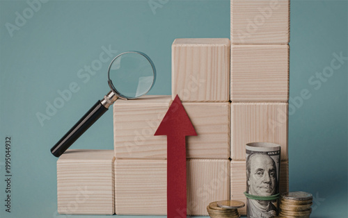 Increasing financial growth with wooden blocks magnifying glass and money