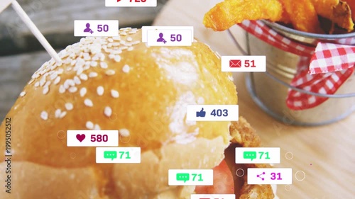 Stacked burger attracting social badges after alert ping, revealing fries while showing engagement