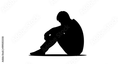 Silhouette of a man sitting with his knees drawn up to his chest