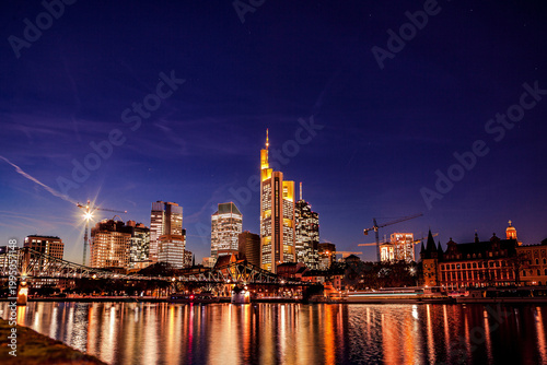 Bilde på lerret Frankfurt city skyline glowing at night over main river