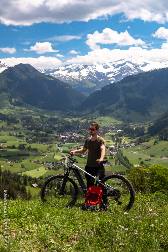 Fototapeta premium Man mountain biking in swiss alps valley