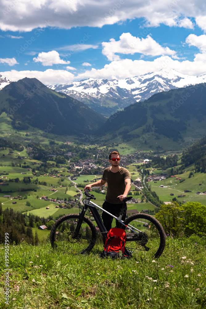 Fototapeta premium Man with mountain bike enjoying scenic mountain view