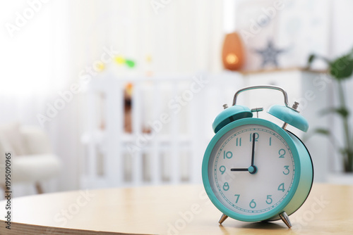 Schilderij op canvas Alarm clock on table in nursery, closeup. Space for text