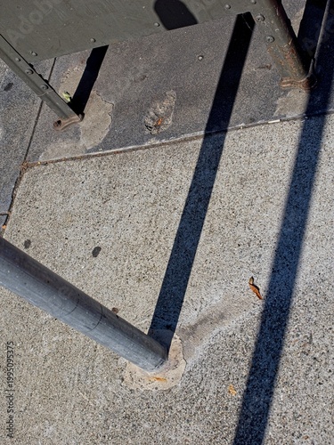 sidewalk mounted pole, mailbox with shadows