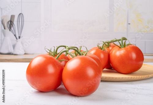 Tomatoes, beautiful red tomatoes in rustic bowls on a very bright kitchen counter, selective focus.