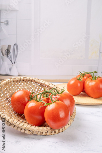 Tomatoes, beautiful red tomatoes in rustic bowls on a very bright kitchen counter, selective focus.