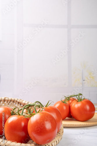 Tomatoes, beautiful red tomatoes in rustic bowls on a very bright kitchen counter, selective focus.