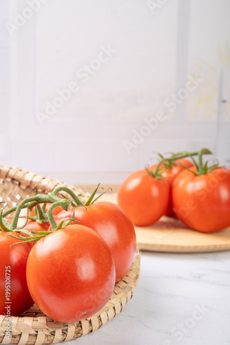 Tomatoes, beautiful red tomatoes in rustic bowls on a very bright kitchen counter, selective focus.