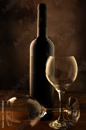 Bottle and wine glass, bottle and wine glass on a rustic wooden surface and abstract background, low key photo, selective focus.