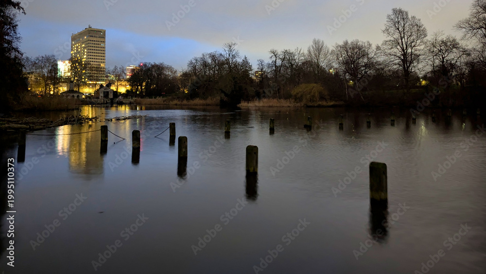 Fototapeta premium London, UK; 13th February 2026: Night view of the Serpentine in Hyde Park with the illuminated Royal Lancaster London hotel rising in the background, reflected on the still water