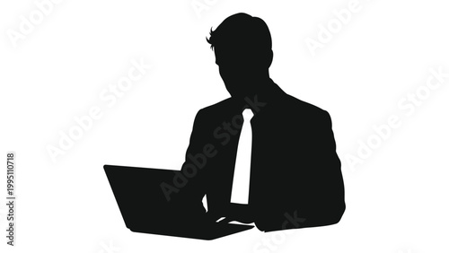 A silhouetted businessman intently works on a laptop focused on the screen