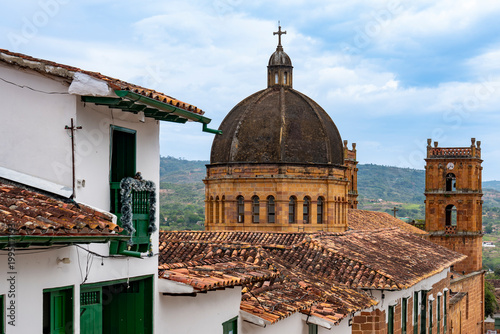 Foto Barichara, Colombia: a street scene featuring traditional houses and a church, with a view of the rooftops